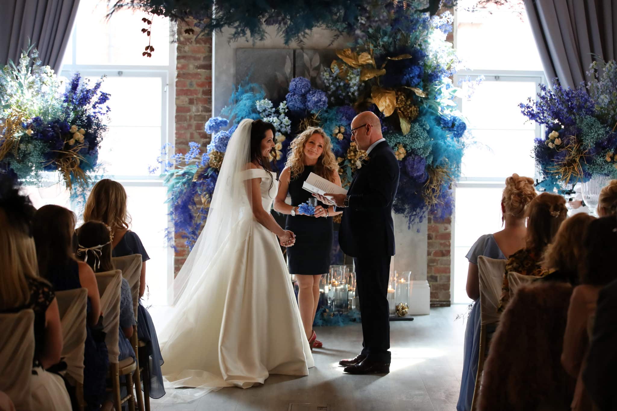 bride and groom reading vows at the alter 